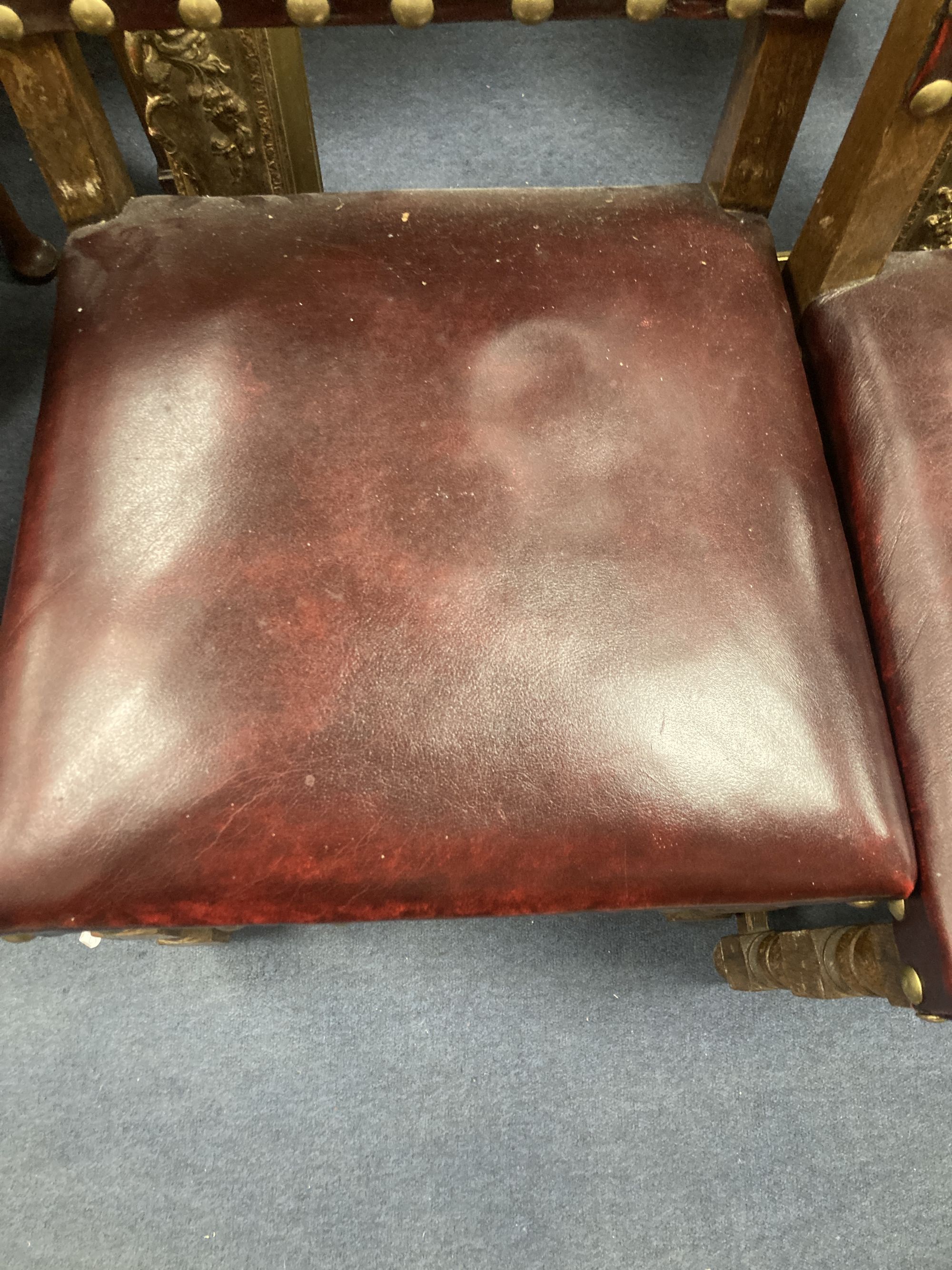 A pair of oak carolean-style dining chairs circa 1880, red leather and studding